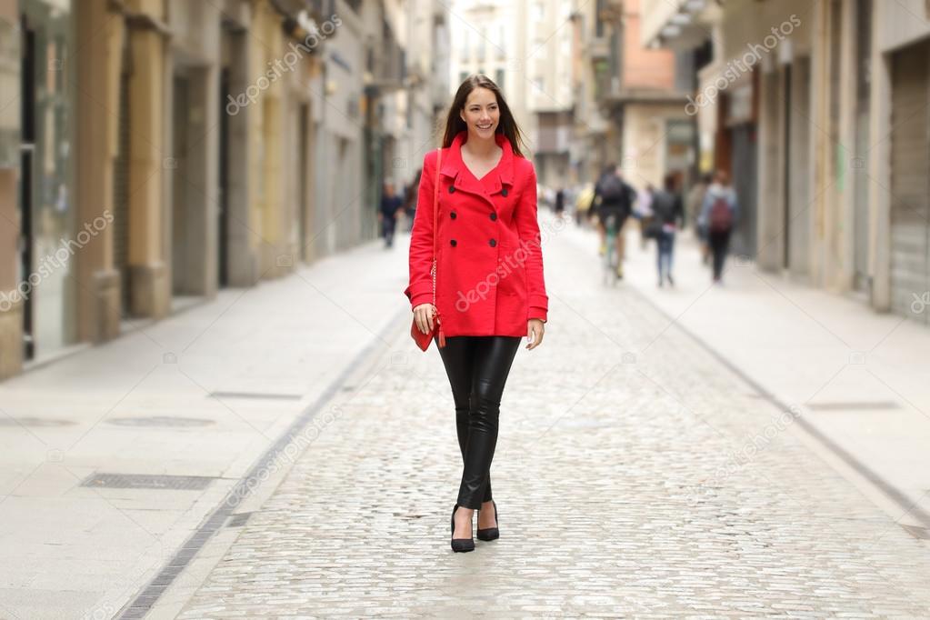 Fashion woman in red walking on a city street