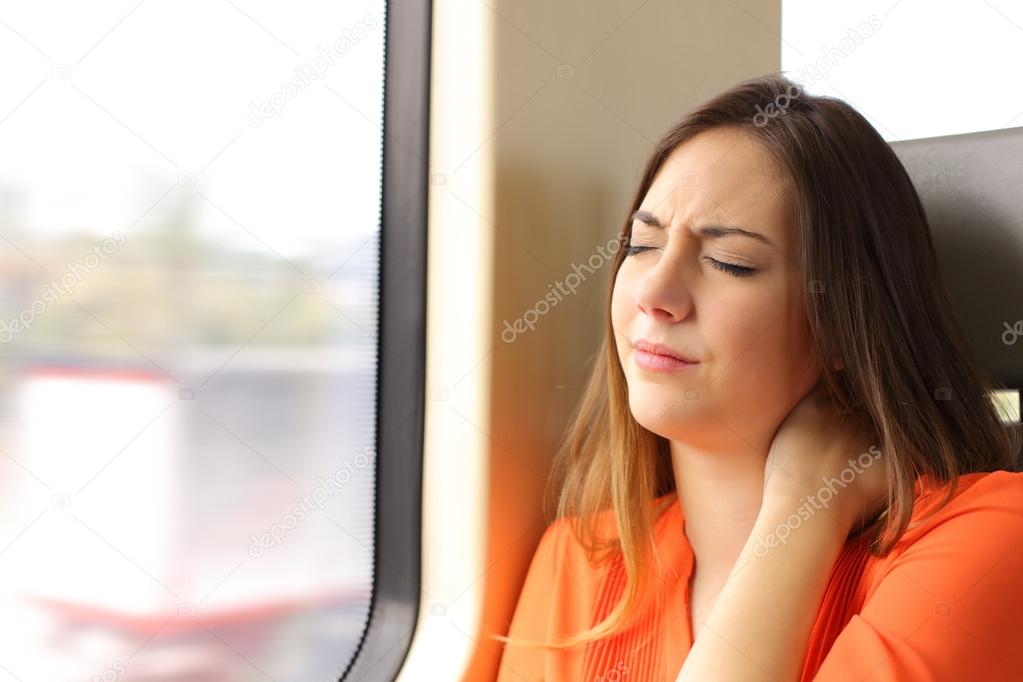 Stressed woman with neck ache in a train wagon