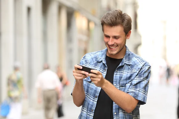 Мужчина играет в игру со смартфоном — стоковое фото