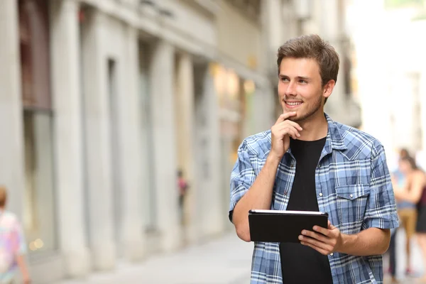 Homem com um tablet a pensar na rua — Fotografia de Stock