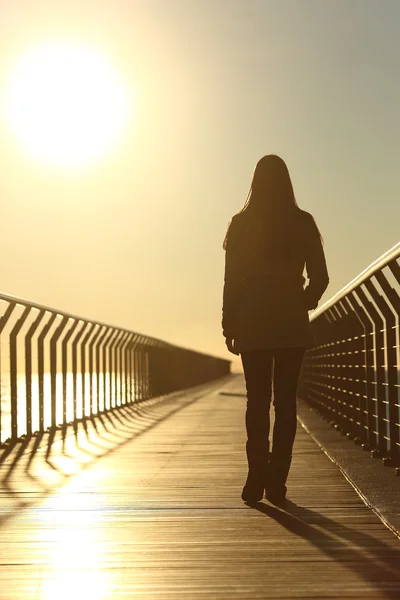 Sad woman silhouette walking alone at sunset — Stock Photo, Image