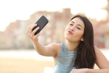 Genç kız bir selfie bir akıllı telefon ile fotoğraf çekimi