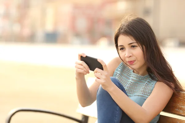 Rolig tonåring spela spel på en smart telefon — Stockfoto