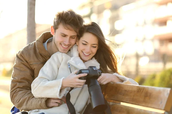 Para turystów przeglądając zdjęcia z aparatu dslr — Zdjęcie stockowe