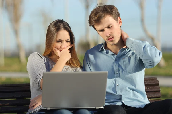 Estudantes ou empresários preocupados assistindo um laptop ao ar livre — Fotografia de Stock