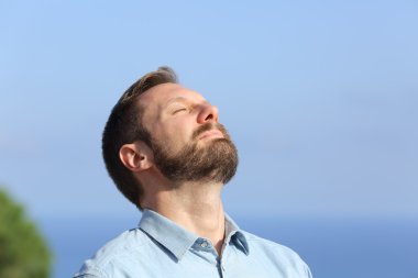 Man breathing deep fresh air outdoors clipart