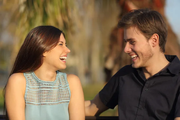 Vrienden lachen en het nemen van een gesprek in een park — Stockfoto