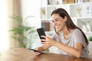 Evdeki yeni uygulamalara telefon yükleyen kadın