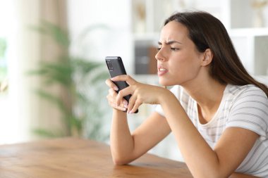 Genç kadın evde telefon içeriğini kontrol etmeye zorlanıyor.