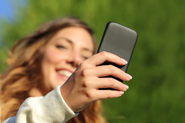 Visão inferior de uma mulher mão mensagens de texto em um telefone inteligente — Fotografia de Stock
