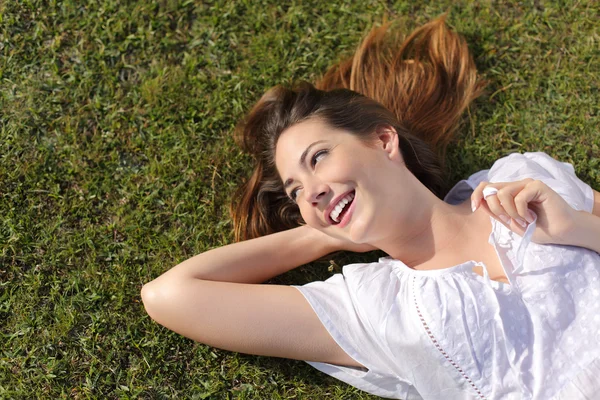 Glücklich entspannte Frau auf dem Gras liegend — Stockfoto