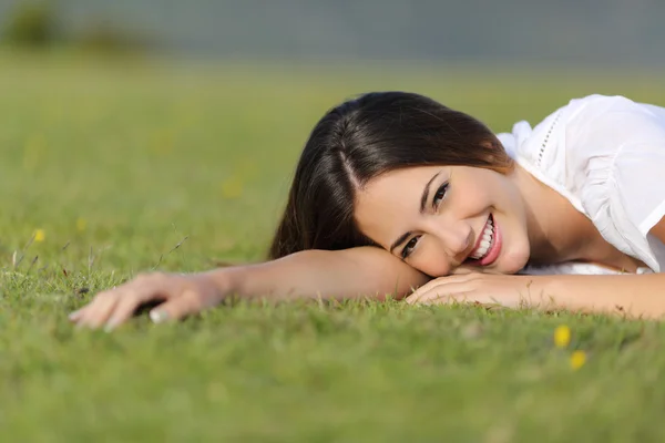 Boldog asszony mosolygó és pihenés nyugodt a fűben — Stock Fotó
