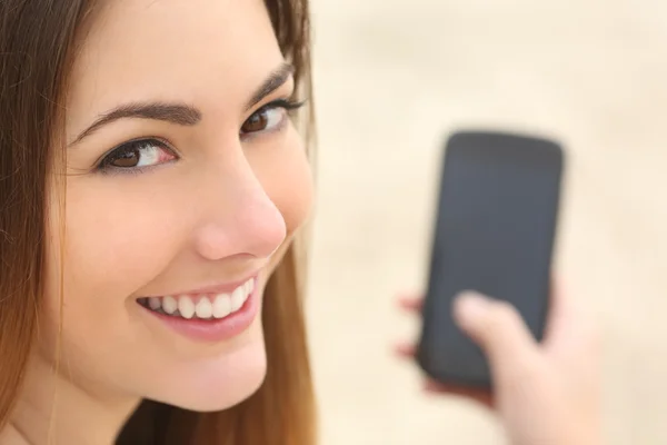 Retrato de una mujer sonriente usando un teléfono inteligente —  Fotos de Stock