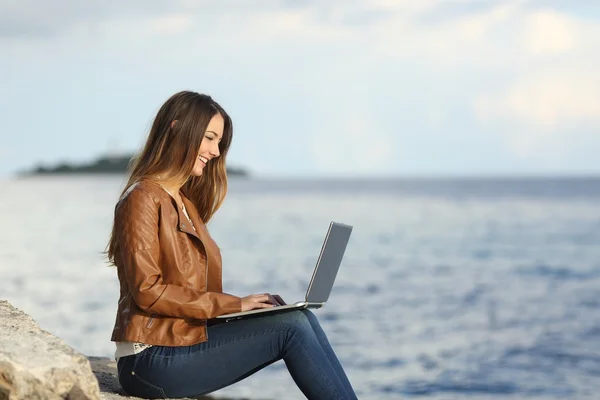 Mulher autônoma trabalhando com um laptop na praia — Fotografia de Stock