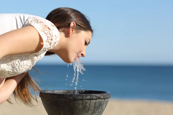 Mujer bebiendo agua de una fuente — Foto de Stock
