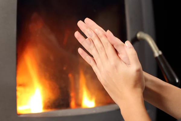 Femme mains chauffage devant une cheminée — Photo