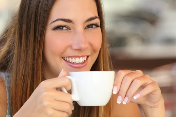 Frau probiert einen Kaffee aus einer Tasse auf der Restaurantterrasse — Stockfoto