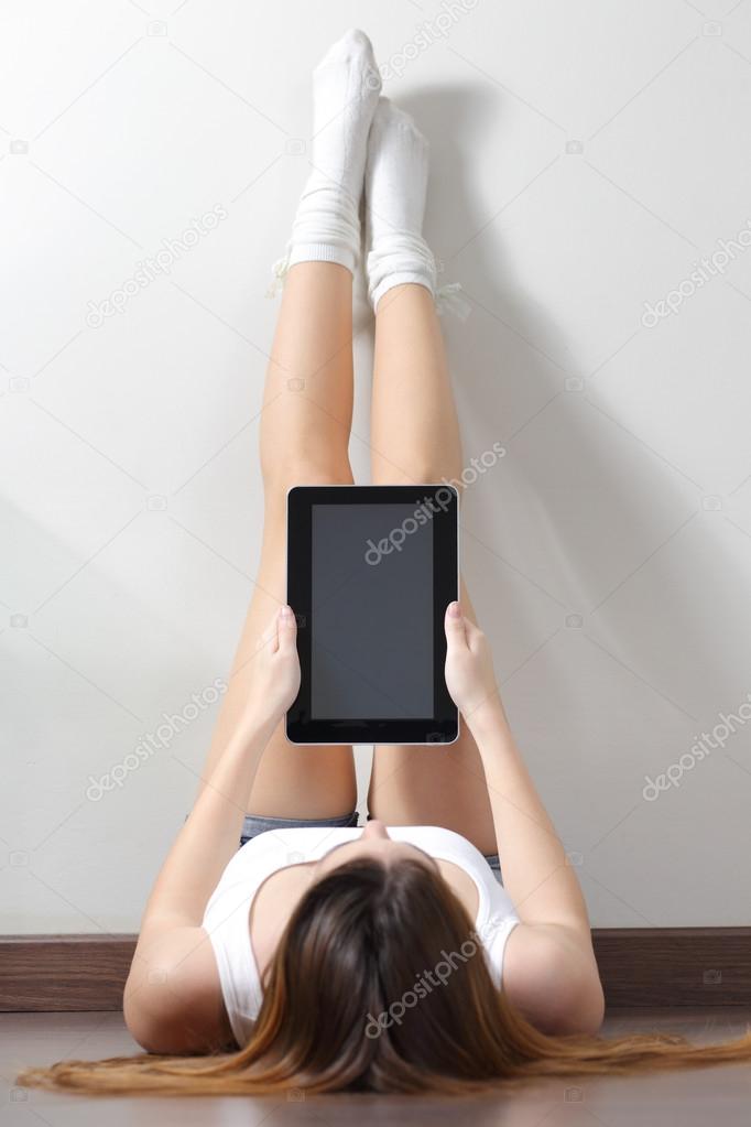 Woman sitting on the floor reading a tablet reader