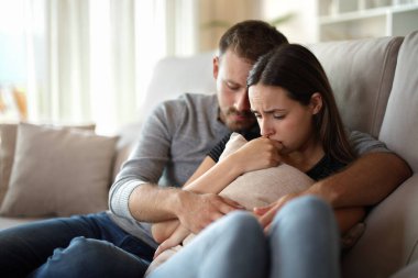 Üzgün çift evdeki kanepede oturup şikayet ediyor.