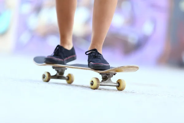 Adolescente skater menina pernas em um skate bordo — Fotografia de Stock
