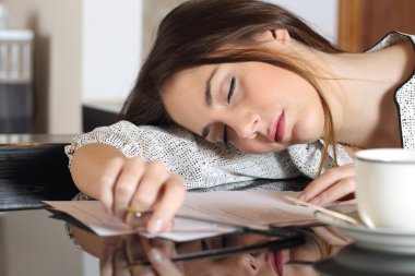 Tired overworked woman resting while writing notes clipart
