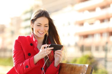 Bir akıllı telefon kulaklık ile videoları izlerken kadın