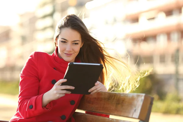 Mulher lendo um ebook ou tablet em um parque urbano — Fotografia de Stock