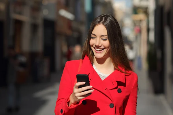 Женщина с помощью смартфона во время прогулки по улице — стоковое фото