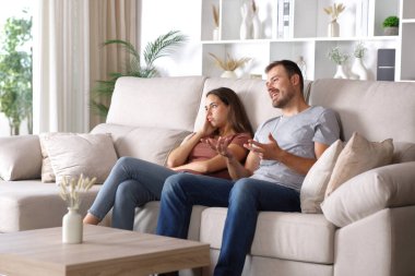 Evde kanepede oturan partnerini dinleyen sıkıcı bir kadın.