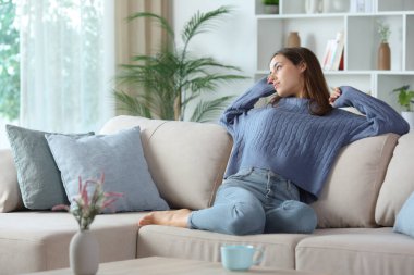 Evdeki koltukta oturan mavi kollu kadın.