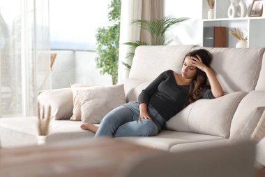 Üzgün kadın evin içindeki bir kanepede tek başına oturmaktan şikayetçi.