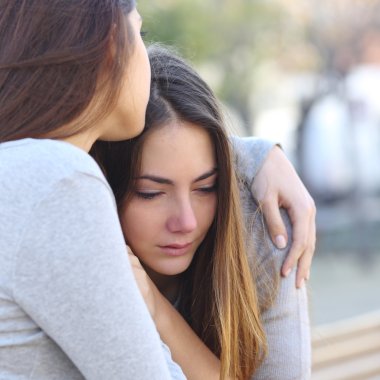 Sad girl crying and a friend comforting her