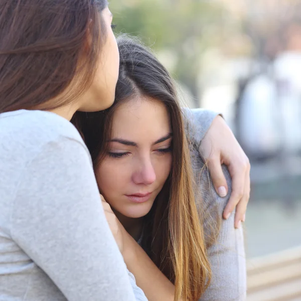 Trauriges Mädchen weint und ein Freund tröstet sie — Stockfoto