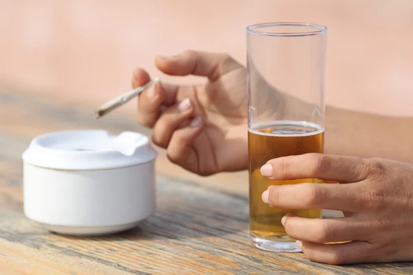 Hands holding a cigarette smoking and drinking alcohol — Stock Photo, Image