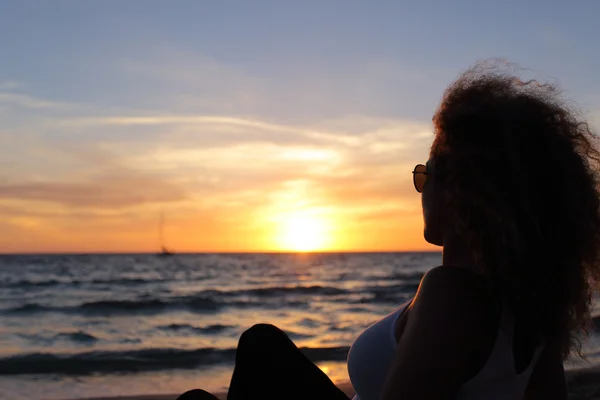 Kvinnan silhouette tittar på en solnedgång i Ibiza — Stockfoto