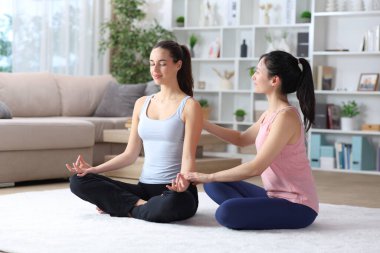 Evde halıda yoga öğreten özel öğretmen.