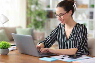 Gözlük takarak evde dizüstü bilgisayar kullanarak mutlu bir iş.