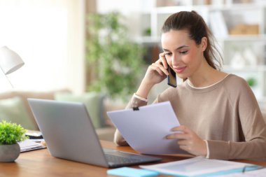 Ücretsiz çalışan, telefonda kağıt işleri hakkında konuşuyor.