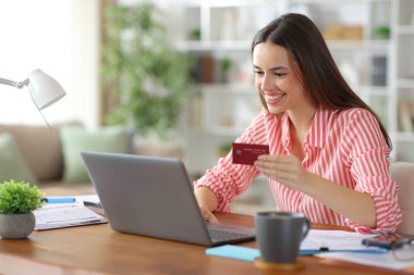 Serbest meslek evde dizüstü bilgisayar ve kredi kartı kullanarak çalışır ve ödeme yapar.