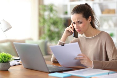 Kafası karışmış bir televizyon çalışanı, evde çalışan kağıt raporları hakkında telefonda konuşuyor.