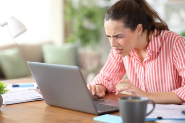 Tele çalışanı evde çalışırken dizüstü bilgisayar kullanarak göz yorgunluğu çekiyor