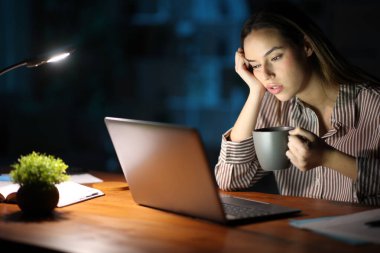 Geceleri evde kahve içerek çok çalışan yorgun serbest çalışan bir işçi.