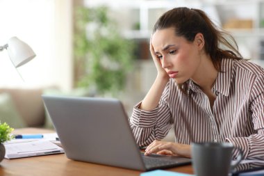 Yorgun haldeki serbest meslek sadece evde dizüstü bilgisayarı kontrol ediyor.