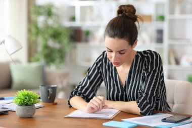 Evde çalışan, okuma ve doldurma formları dolduran serbest çalışan bir işçi.