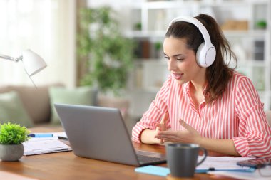 Teleworker evde çalışan kulaklık ve kişisel bilgisayarla video görüşmesi yapıyor.