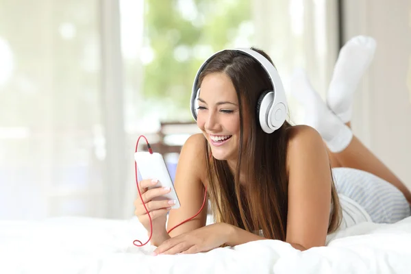 Ragazza che ascolta musica da uno smartphone a casa — Foto Stock