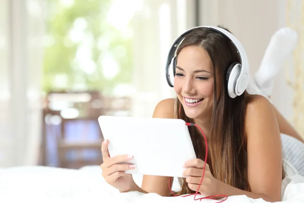 Chica escuchando música desde una tableta en casa — Foto de Stock