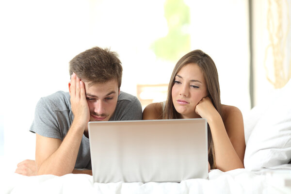 Bored marriage watching media in a laptop