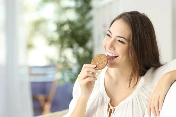 Chica feliz comiendo una galleta dietética — Foto de Stock