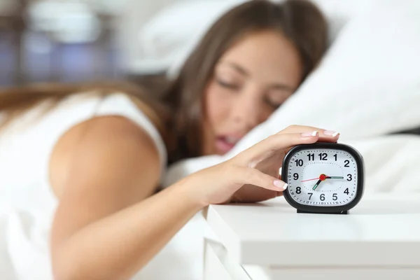 Wake up of an asleep girl stopping alarm clock — Stock Photo, Image